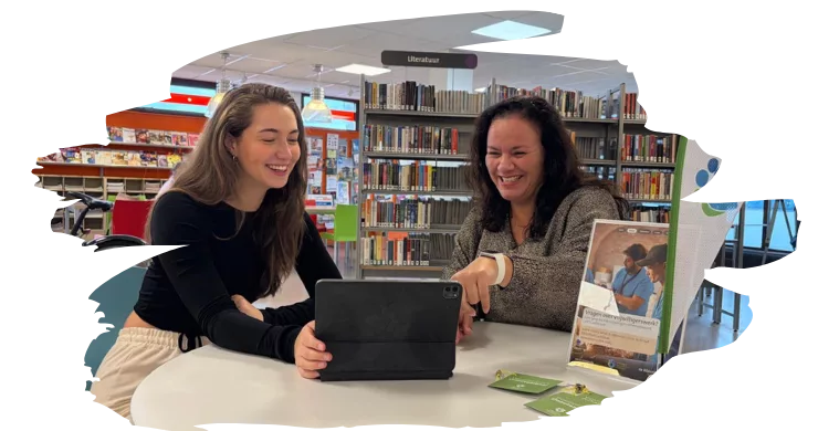 Vrijwilligers en medewerker van het Vrijwilligers informatie punt zoeken samen een vacature uit.